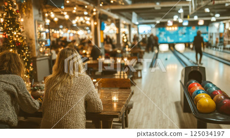 Festive bowling alley with people dining and celebrating, warm lights and a cozy holiday atmosphere 125034197