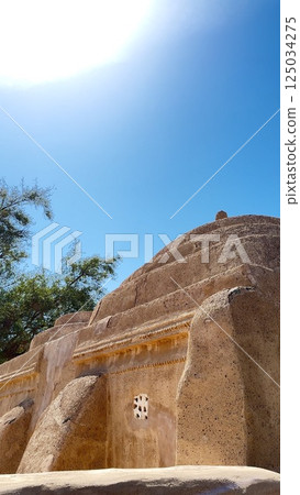 Fujairah, UAE - March 08, 2025: Al Bithnah Fort , Al Bidya Mosque. Distinctive Asir mud-brick buildings stand beneath radiant sunlight, intricate geometric patterns adorning stone walls Fujairah, UAE - March 08, 2025: Al Bithnah Fort , Al Bidya Mosque. Distinctive Asir mud-brick buildings stand beneath radiant sunlight, intricate geometric patterns adorning stone walls 125034275