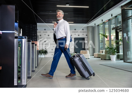 Passenger in suit heading to gate for his business trip 125034680