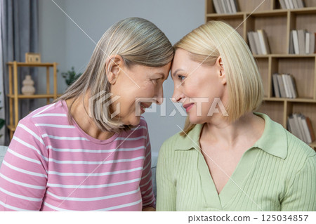 Smiling women hugging each other, smiling and feeling close Smiling women hugging each other, smiling and feeling close 125034857