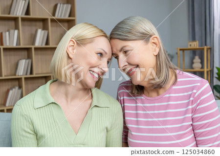 Smiling women hugging each other, smiling and feeling close Smiling women hugging each other, smiling and feeling close 125034860
