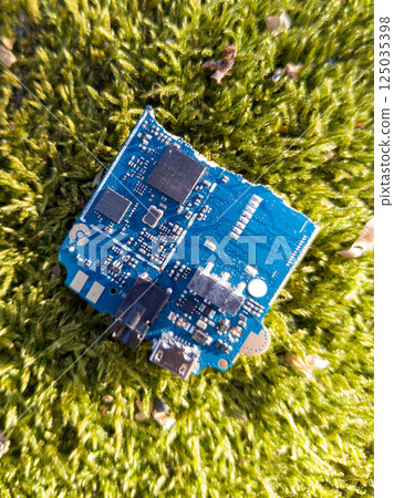 Discarded Circuit Board on Green Surface Discarded Circuit Board on Green Surface 125035398