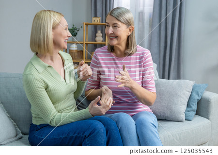 Two women sitting on the sofa and having a nice talk 125035543