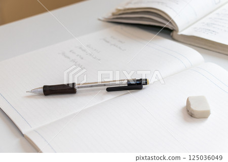 Pen and eraser on an open notebook 125036049
