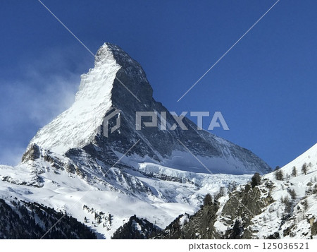 Snow-covered Matterhorn and blue sky landscape photo Snow-covered Matterhorn and blue sky landscape photo 125036521