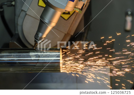 Close up scene the multi axis fiber laser cutting machine cut the stainless steel tube with sparkling light. 125036725