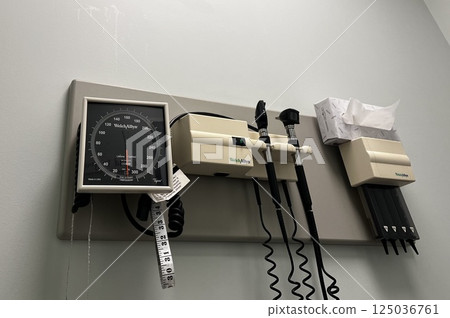 Medical equipment such as a blood pressure measuring machine installed on the wall of a hospital examination room 125036761