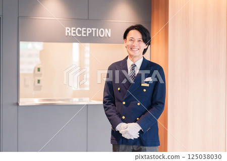 一位男酒店服務生微笑著為顧客服務 125038030