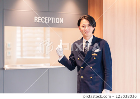 一位男酒店服務生微笑著為顧客服務 125038036