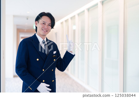 一位男酒店服務生微笑著為顧客服務 125038044