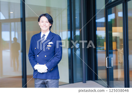 A male hotel attendant serving customers with a smile A male hotel attendant serving customers with a smile 125038046