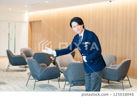 一位男酒店服務生微笑著為顧客服務 125038048