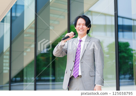 一名西裝革履的男子在街頭用麥克風發表演講 125038795