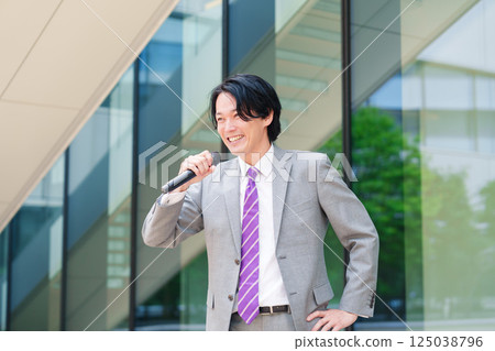 一名西裝革履的男子在街頭用麥克風發表演講 125038796