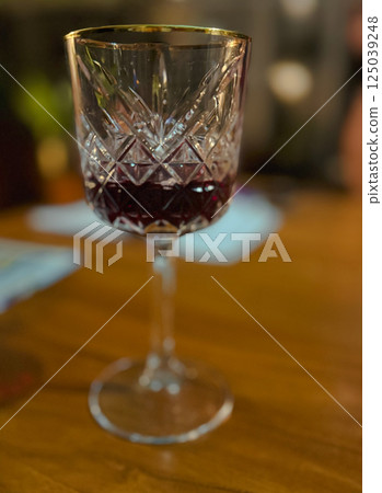 Small glass with a drink - whiskey, cognac, rum, port or even juce.Concept of holiday, romance or luxury 125039248