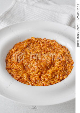 Creamy tomato risotto on clean white plate 125039364