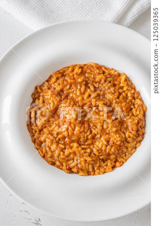Creamy tomato risotto on clean white plate Creamy tomato risotto on clean white plate 125039365