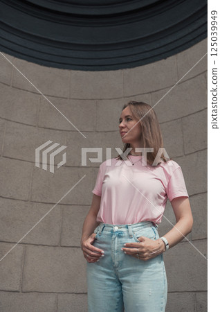 Casual Young Woman Leaning Against Stone Wall 125039949