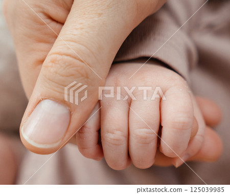 baby's hand and mom's palm. baby's fist in mom's hand. High quality photo baby's hand and mom's palm. baby's fist in mom's hand. High quality photo 125039985