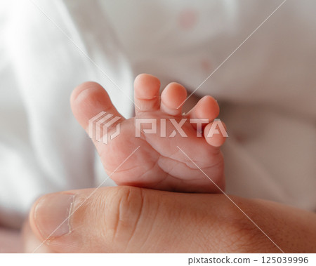 A newborn baby's feet in mom s hands close-up. High quality photo 125039996