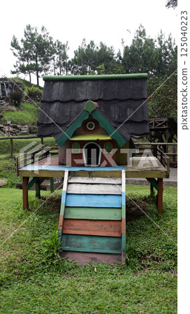 Colorful Rabbit House in Lush Green Yard with Multiple Rabbits Resting at a Cozy Small Animal Shelter 125040223