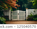 Elegant White Wooden Gate Amidst Lush Greenery and Autumn Foliage 125040570