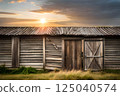 Golden Sunset Over Rustic Wooden Barn Amidst Tranquil Countryside 125040574