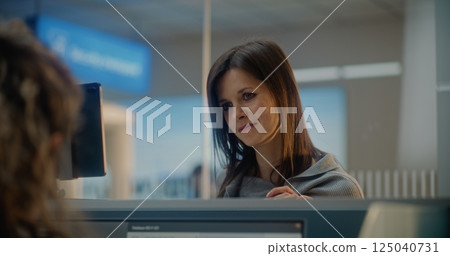 Check-in Counter: Close Up of Woman Talking to Airline Worker, Waiting for Passport Check 125040731