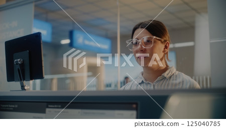 Airport Check-in Counter: Woman Giving Passport and Airplane Ticket to Airline Agent 125040785