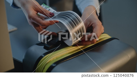 Close Up of Female Airline Worker Putting Luggage Tag Sticker on Suitcase 125040876