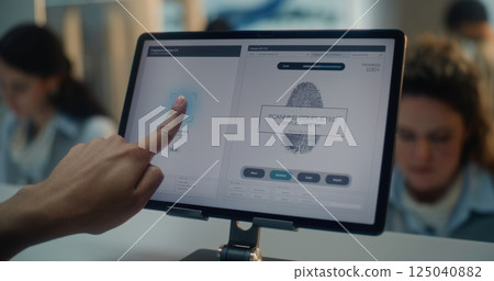 Airport Check-in Counter: Close Up of Indian Tourist Putting Finger on Touch Screen for Fingerprint Scanning Airport Check-in Counter: Close Up of Indian Tourist Putting Finger on Touch Screen for Fingerprint Scanning 125040882