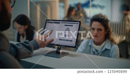 Airport Check-in Counter: Man Puts Finger on Touch Screen for Identification by Scanning Fingerprint 125040899