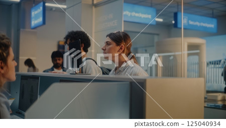 Airport Check-in Counter: Woman Giving Passport, Verifying by Facial Recognition Scanning Airport Check-in Counter: Woman Giving Passport, Verifying by Facial Recognition Scanning 125040934