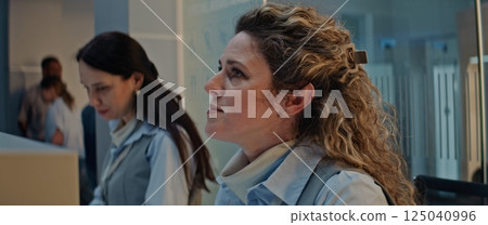 Close Up of Female Airline Workers Accepting and Checking Documents and Airplane Tickets of Passengers Close Up of Female Airline Workers Accepting and Checking Documents and Airplane Tickets of Passengers 125040996