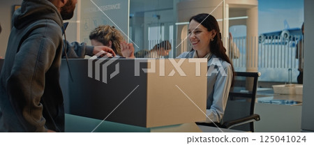 Female Airline Worker Talking and Checking Documents of Passenger at Airport Check-in Counter 125041024