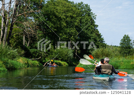Group kayak trip for seigneur and senora. An elderly couple And adult rowing boat on the river, a water hike, a summer adventure. Age-related sports, mental youth and health, tourism, active old age 125041128