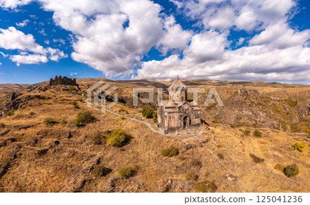 Aerial drone view of famous Vahramashen Church of the 11th century, located near destroyed Amberd fortress in sunny summer day. Cliff with Arkashian River deep in canyon. Aragatsotn region, Armenia Aerial drone view of famous Vahramashen Church of the 11th century, located near destroyed Amberd fortress in sunny summer day. Cliff with Arkashian River deep in canyon. Aragatsotn region, Armenia 125041236