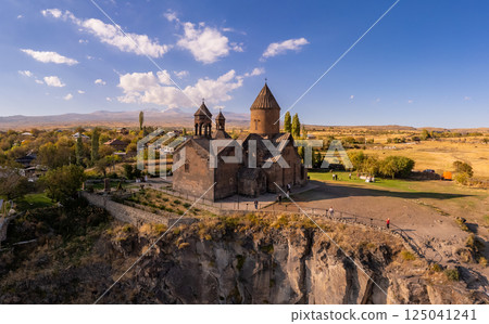 Aerial top view of Saghmosavank Monastery 13h centuries is located huge gorge canyon of Kasakh River. Church and Mount Ara on beckground in sunny summer day. Saghmosavan, Aragatsotn, Armenia, Europe Aerial top view of Saghmosavank Monastery 13h centuries is located huge gorge canyon of Kasakh River. Church and Mount Ara on beckground in sunny summer day. Saghmosavan, Aragatsotn, Armenia, Europe 125041241
