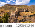 Aerial Panoramic view of medieval castle Khetvisi. Meskheti fortress with tower on rock and Paravani river. Historical sights. Old ruin famous Georgian touristic places. Georgia, Europe 125041249