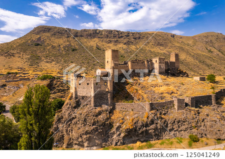 Aerial Panoramic view of medieval castle Khetvisi. Meskheti fortress with tower on rock and Paravani river. Historical sights. Old ruin famous Georgian touristic places. Georgia, Europe Aerial Panoramic view of medieval castle Khetvisi. Meskheti fortress with tower on rock and Paravani river. Historical sights. Old ruin famous Georgian touristic places. Georgia, Europe 125041249