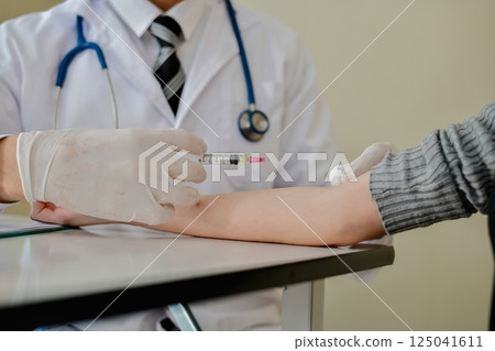 A doctor administers a vaccination to a patient in a clinical setting, highlighting healthcare and wellness. 125041611