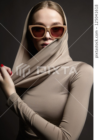 Beautiful young woman in sunglasses and hood Beautiful young woman in sunglasses and hood 125041618