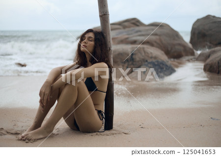 Beautiful young woman on beach. sexy girl in Bikini sitting on sand 125041653