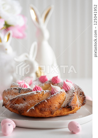Traditional Easter cakes with icing decorated candies on white wooden table 125041952