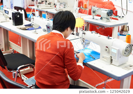 Worker and sewing machine in workshop Worker and sewing machine in workshop 125042029