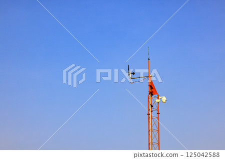wind speed measurement or anemometer on red pole at small weather station. 125042588