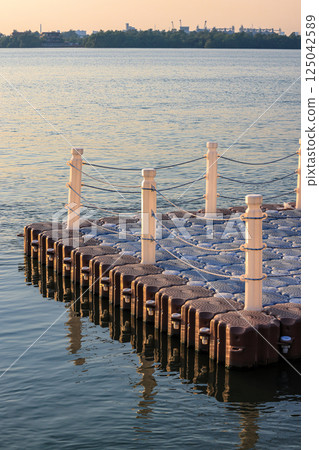 Floating Jigsaw or floating plastic pontoon walk way floating in the sea. Plastic Floating Dock. Plastic Pontoon bridge. Floating Jigsaw or floating plastic pontoon walk way floating in the sea. Plastic Floating Dock. Plastic Pontoon bridge. 125042589