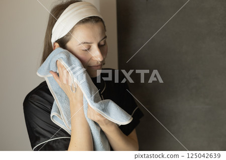 woman wiping her face with a towel woman wiping her face with a towel 125042639