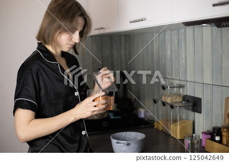 woman opening a container of lentils in the kitchen woman opening a container of lentils in the kitchen 125042649