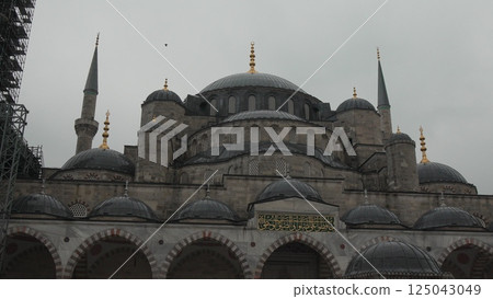 Istanbul Blue Mosque Architecture Ottoman: Cloudy day historical landmark showcasing domes, minarets, and stonework. Istanbul Blue Mosque Architecture Ottoman: Cloudy day historical landmark showcasing domes, minarets, and stonework. 125043049